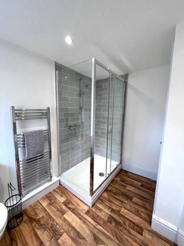 a bathroom with a shower and a wooden floor at Outdoor Patio, Near Stadium Of Light, Refurbished in Monkwearmouth