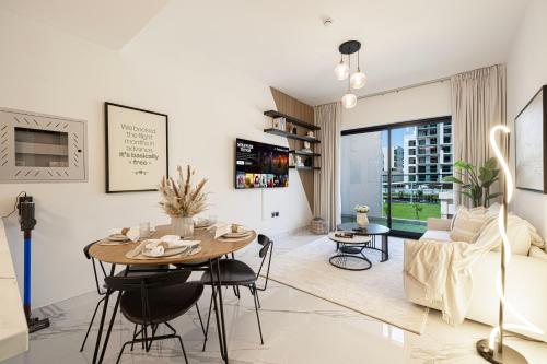 a living room with a table and a couch at Brand New 1BR with Pool, Sauna & Gym in Dubai