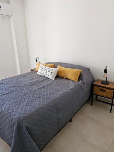 サンフアンにあるDepto Alem y Central RFのベッド1台(青い掛け布団、黄色い枕付)