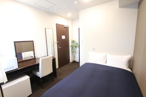 a room with a bed and a desk and a computer at HOTEL LiVEMAX Higashi Ginza in Tokyo