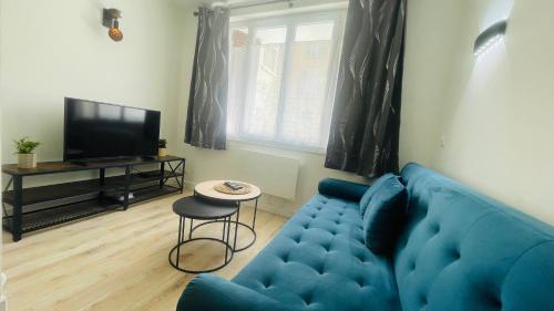 un salon avec un canapé bleu et une télévision dans l'établissement L'Appart chic, à Digne-Les-Bains
