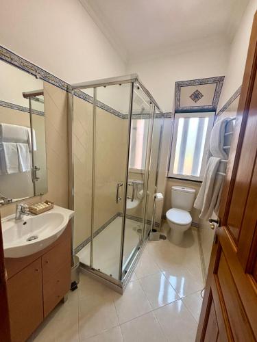 a bathroom with a shower and a sink and a toilet at Casa da Villa 1A in Sintra