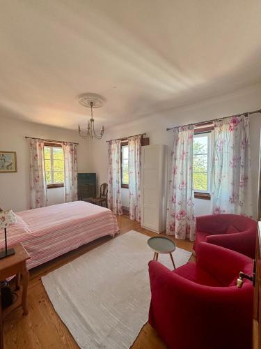 a bedroom with a bed and two red chairs at Casa da Villa 1A in Sintra