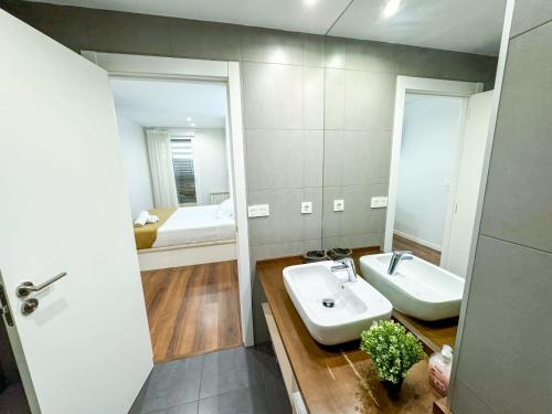 un bagno con lavandino, specchio e letto di El Olivo del Pilar Turistea a Saragozza