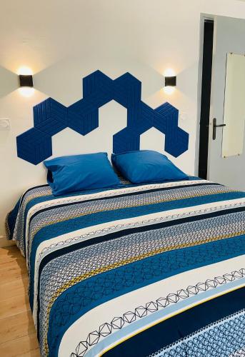 - un grand lit avec une tête de lit bleue et des oreillers bleus dans l'établissement L'Appart chic, à Digne-Les-Bains