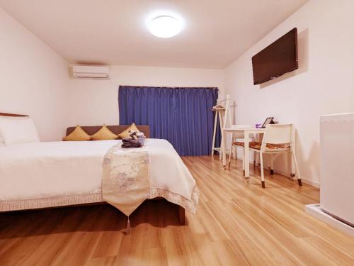 a bedroom with a bed and a table and a tv at Rosenheim Tokyo Shinjuku in Tokyo