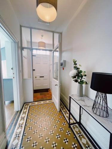 a hallway with a white door and a tile floor at Amber House in Gorleston-on-Sea
