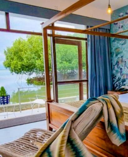a bedroom with a canopy bed with a window at Kalpitiya Chalets by Thilanka in Kalpitiya