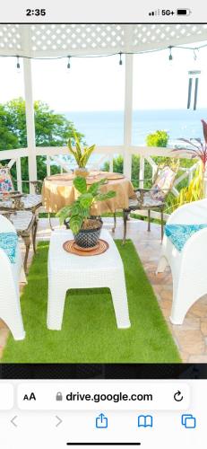 a white table with a potted plant on a porch at One more night in Ocho Rios