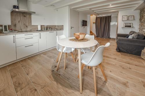 a kitchen and living room with a table and chairs at Grange Rénovée 3 pers-Le GrandLieu-Gîte Le 411 in Saint-Philbert-de-Grand-Lieu