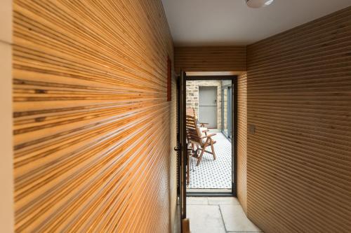 a wooden pivot door in a room with a wooden wall at Stanage Barn By Birch Stays in Hathersage