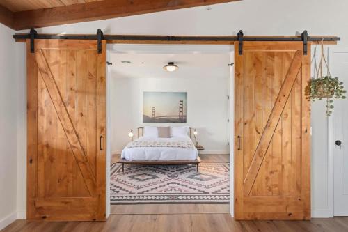 a bedroom with a bed through a sliding barn door at The Raven By The Cohost Company in Pioneertown