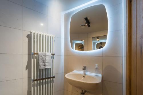 a white bathroom with a sink and a mirror at Stanage Barn By Birch Stays in Hathersage