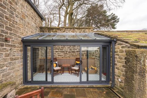 an extension to a conservatory with a table and chairs at Stanage Barn By Birch Stays in Hathersage