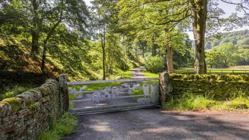 a stone fence with graffiti on it next to a road at Stanage Barn By Birch Stays in Hathersage