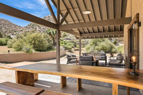 a wooden table on a patio with mountains in the background at The Raven By The Cohost Company in Pioneertown