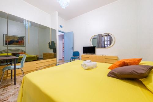 a bedroom with a yellow bed with a table and chairs at Casa Aurora in Pace Inferiore