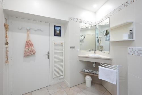 een witte badkamer met een toilet en een wastafel bij Cocon Douillet, plages à 2 pas in La Noue