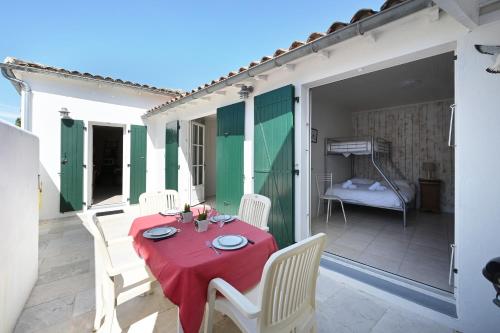 - une table et des chaises sur une terrasse avec un lit dans l'établissement Cocon Douillet, plages à 2 pas, à La Noue