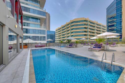 a large swimming pool in the middle of a building at SUHA Mina Rashid Hotel Apartments in Dubai