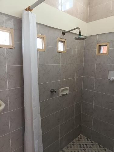 a bathroom with a shower with a shower curtain at Lombok Sunset Hideaway in Lembar