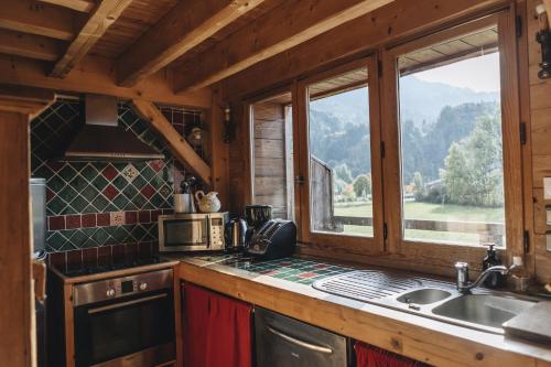 - une cuisine avec évier et une fenêtre dans une cabine dans l'établissement La table de Fifine - Montagne - Appartement 65m2, à Samoëns