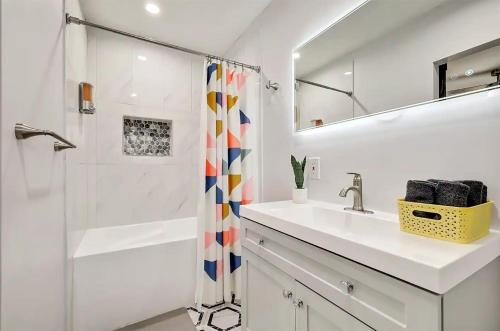 Un baño blanco con lavabo y ducha. en Upscale 3BR 2BA Cozy Holiday Home with Pool & Grill, en North Richland Hills