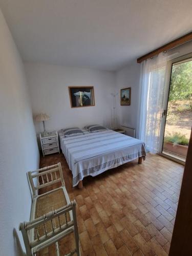 une chambre blanche avec un lit et une fenêtre dans l'établissement La Passiflore, à Saint-Raphaël