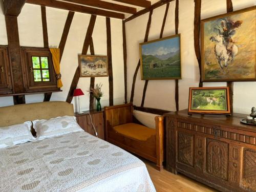 une chambre avec un lit et des tableaux au mur dans l'établissement Les Côtières, à Maresville
