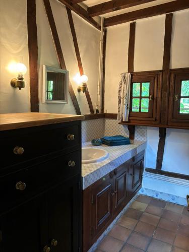 une salle de bain avec un lavabo et un miroir dans l'établissement Les Côtières, à Maresville