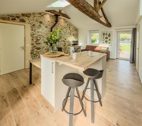 une cuisine avec un grand îlot et deux tabourets dans l'établissement Grange Rénovée 5 personnes-Gîte Le 411, à Saint-Philbert-de-Grand-Lieu