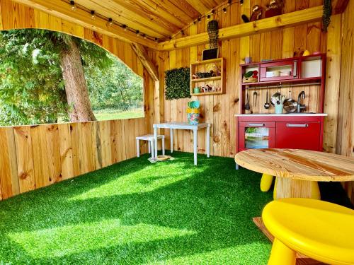 a room with green grass in a wooden cabin at Houses with a View#Sauna#Jaccuzi in Gozdowice