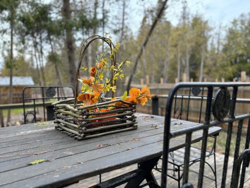 a basket of flowers sitting on a wooden table at Artistic Haven By The Beach in Wiarton