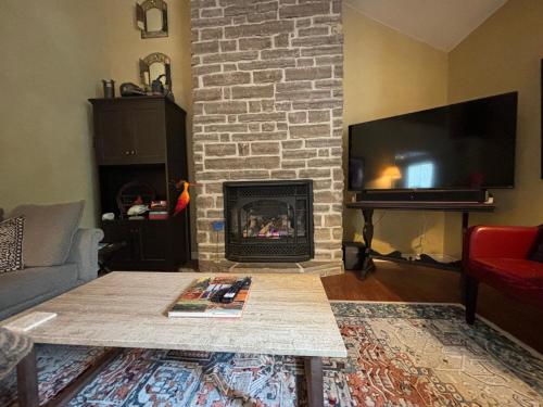 a living room with a fireplace and a tv at Artistic Haven By The Beach in Wiarton