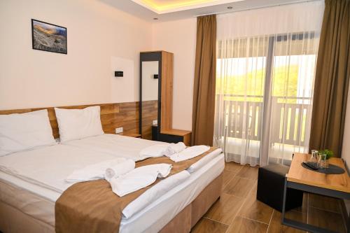 a bedroom with a bed with towels on it at Къща Александра 2 in Dobrinishte