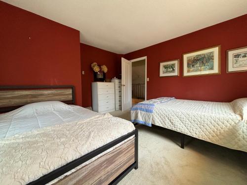 two beds in a bedroom with red walls at Artistic Haven By The Beach in Wiarton
