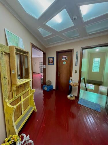 a living room with a vaulted ceilings and red floors at Casa do Rogerio Hostel - Unidade Shopping in Caxias do Sul
