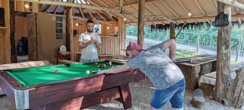 a man playing pool in a room with a pool table at Cabane Salamandre in Saint-Éloy-les-Tuileries