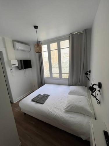 une chambre avec un lit blanc et une fenêtre dans l'établissement Small, Studio Cosy, à Reims