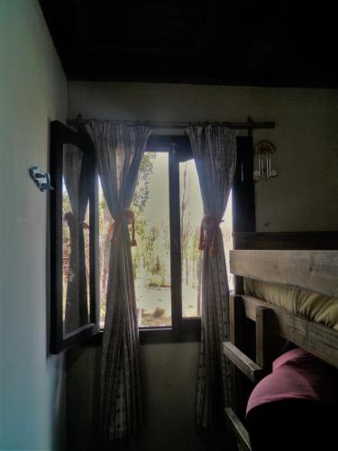 a window in a room with curtains and a bed at Cabaña Terra Nostra in Potrerillos