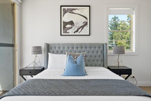 a bedroom with a bed with a blue pillow on it at South Head - Premier Penthouse w Amazing Views in Sydney