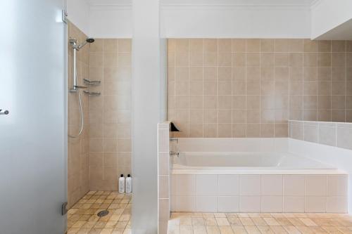 a bathroom with a white tub and a shower at South Head - Premier Penthouse w Amazing Views in Sydney