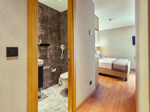 a bathroom with a toilet sink and a bed at Thank You Hotel Sultanahmet in Istanbul