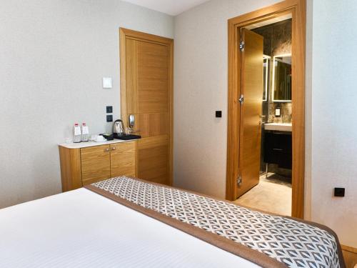 a bedroom with a bed and a bathroom with a sink at Thank You Hotel Sultanahmet in Istanbul