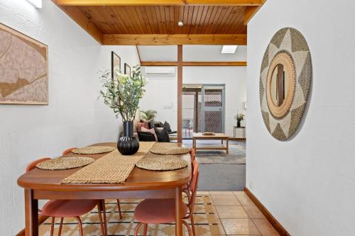 a dining room with a wooden table and chairs at 23 Cottesloe Steps to beach - sleeps 3 NO WIFI in Perth