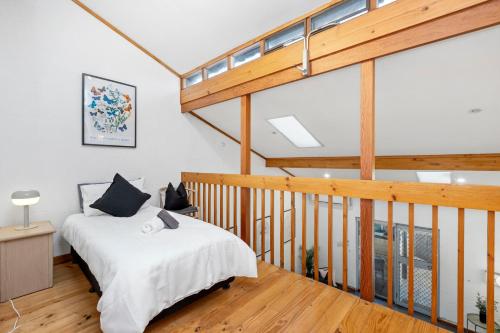 a bedroom with a bed and a wooden staircase at 23 Cottesloe Steps to beach - sleeps 3 NO WIFI in Perth