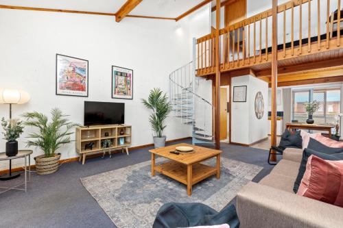 a living room with a couch and a table at 23 Cottesloe Steps to beach - sleeps 3 NO WIFI in Perth
