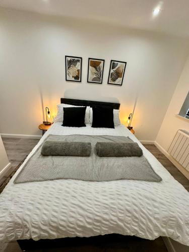 a large white bed in a bedroom with two lamps at Luxe Apartment - Leicester City Centre in Leicester