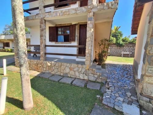 a house with a stone wall and a yard at Pousada Nova Conquista in Penedo