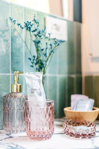 a bottle of perfume and a glass container on a counter at La Lu cozy rooms 2 in Pisa